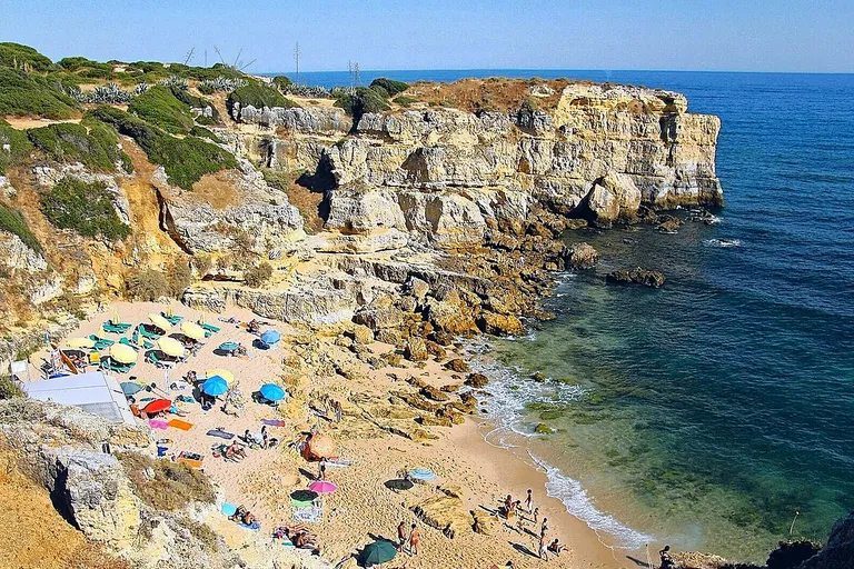 Enseada tranquila da Praia da Coelha, em Albufeira, abrigada por falésias.