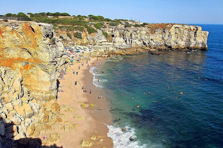 Vista da Praia da Coelha ao fim da tarde, com o mar sereno do Atlântico.