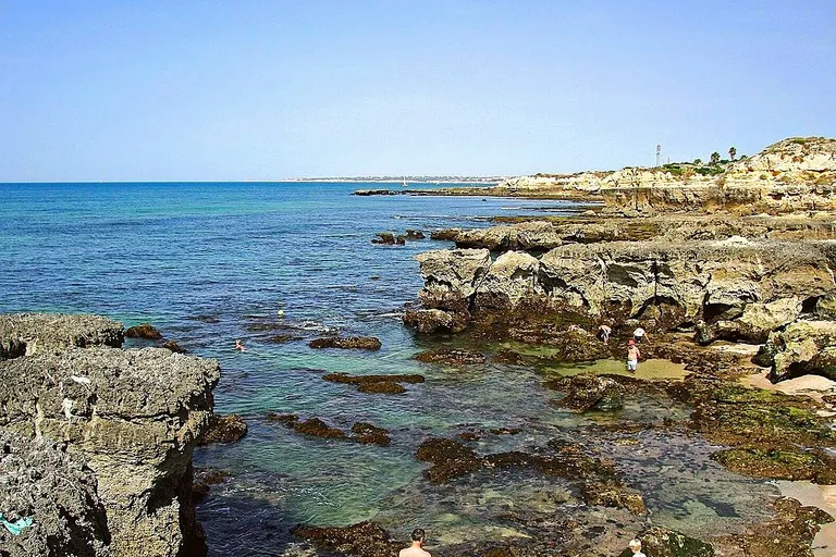 Rochas escultóricas a recortar o areal da Praia do Evaristo, em Albufeira.